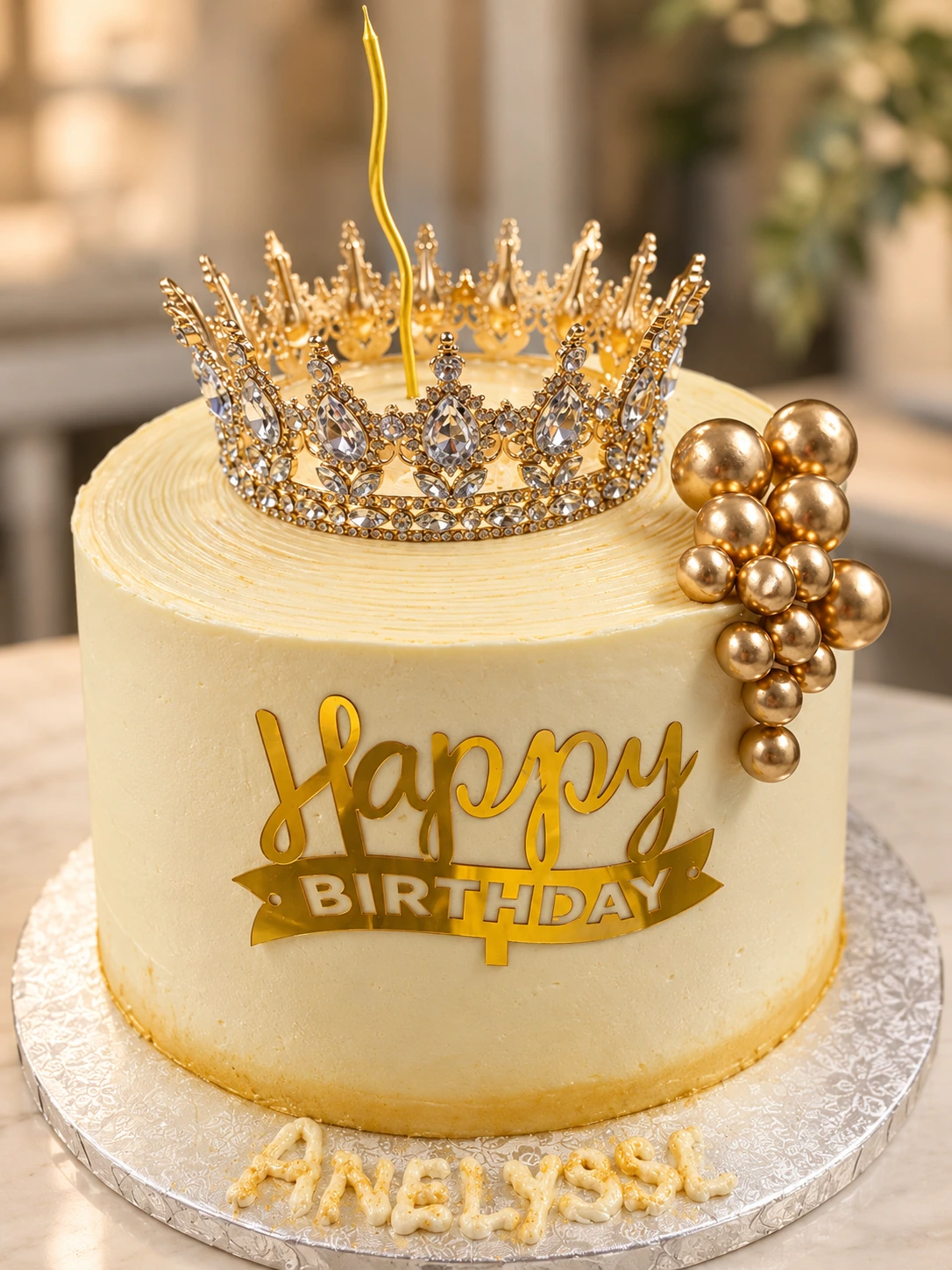 Tarta de princesa con corona dorada, cobertura crema y esferas doradas